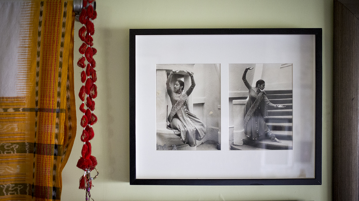 Family photos hanging a wall in which a female dancer holds several poses